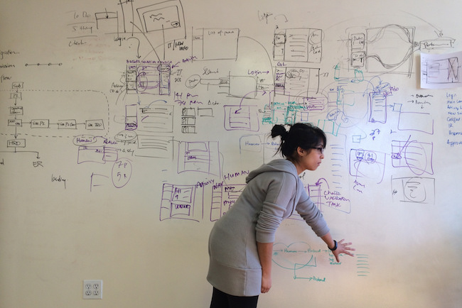 Woman explaining whiteboard diagram